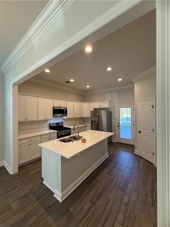 kitchen featuring a center island with sink, stainless steel appliances, sink, white cabinets, and dark hardwood / wood-style floors