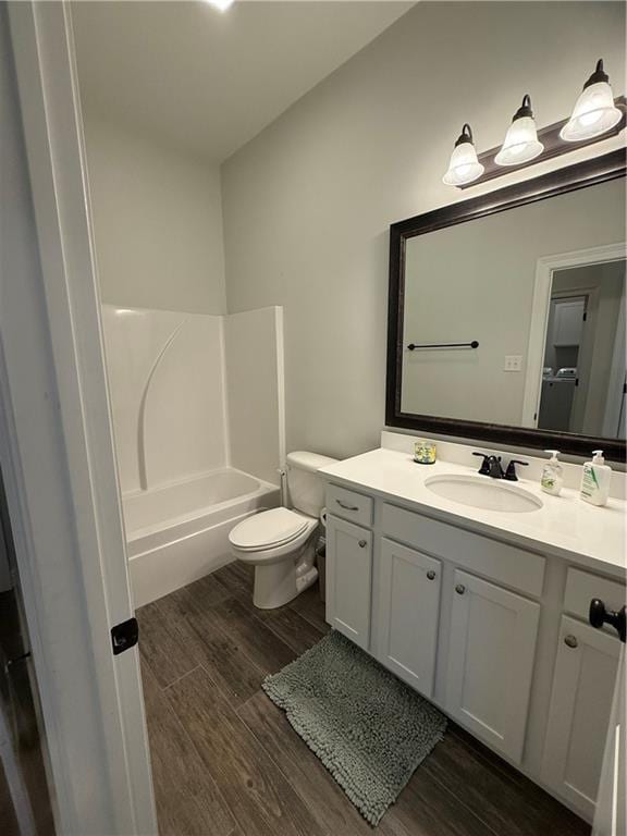 full bathroom with toilet, shower / washtub combination, wood-type flooring, and vanity