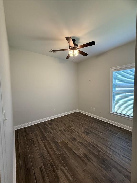 unfurnished room featuring ceiling fan and dark wood-type flooring