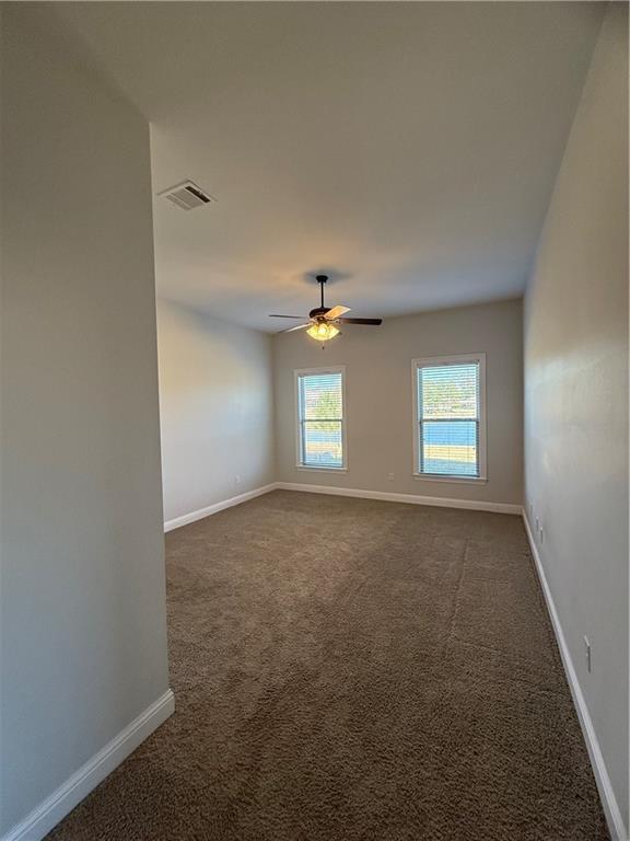 carpeted empty room featuring ceiling fan