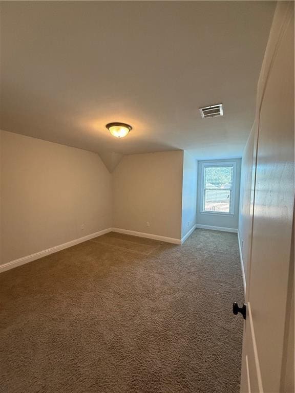 carpeted empty room with lofted ceiling