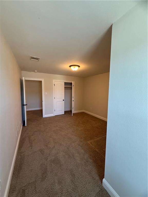 unfurnished room featuring dark carpet