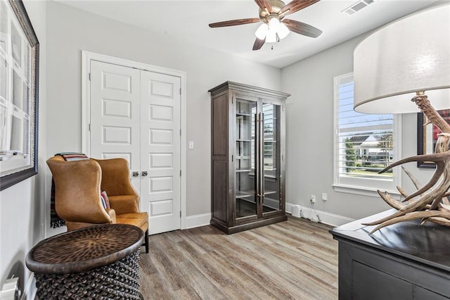 living area with ceiling fan and light hardwood / wood-style flooring