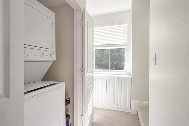 laundry room with light carpet and stacked washing maching and dryer