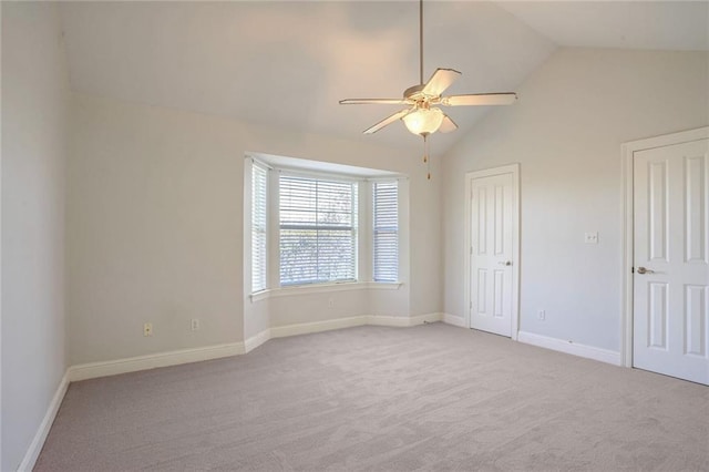 empty room featuring ceiling fan, light colored carpet, and lofted ceiling