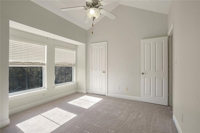 carpeted spare room with ceiling fan and lofted ceiling