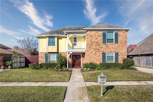 view of front of home featuring a balcony and a front lawn