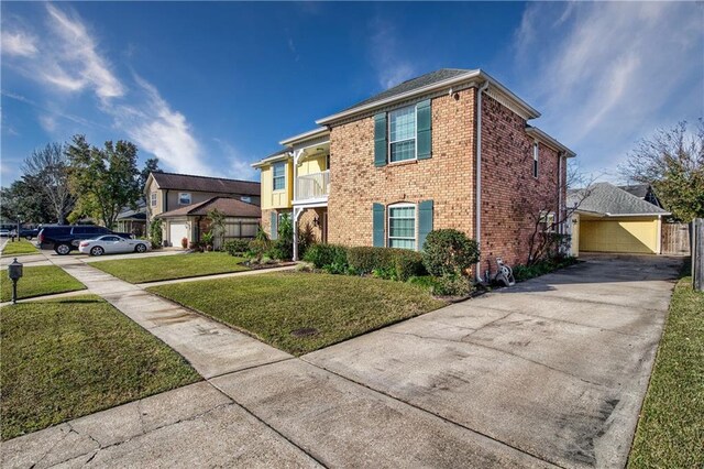 view of front of house featuring a garage, a balcony, and a front lawn