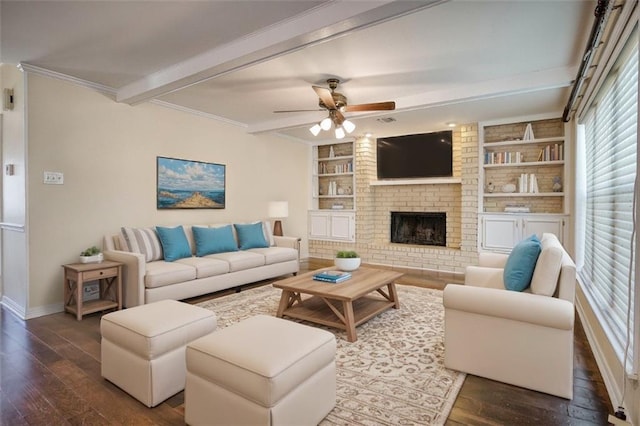 living room featuring a brick fireplace, beam ceiling, dark wood-type flooring, and built in shelves