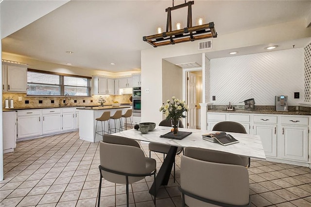 dining area with light tile patterned floors and sink