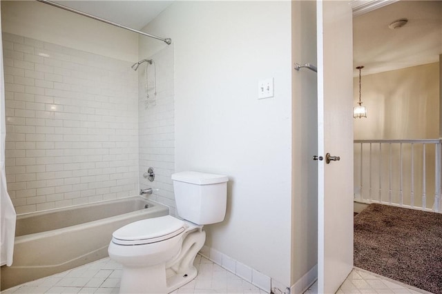 bathroom featuring toilet, tiled shower / bath combo, and tile patterned flooring