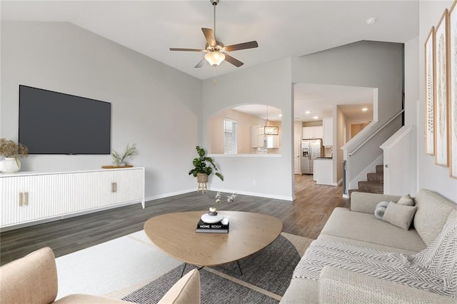 living room with dark hardwood / wood-style floors, ceiling fan with notable chandelier, and vaulted ceiling