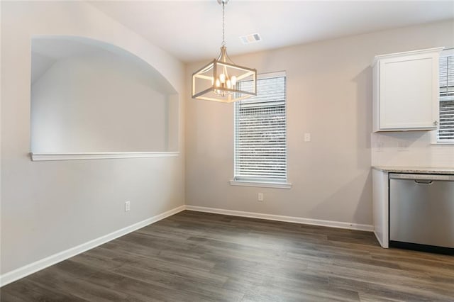 unfurnished dining area featuring dark hardwood / wood-style floors and a notable chandelier