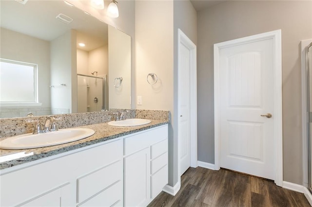 bathroom featuring vanity, wood-type flooring, and walk in shower