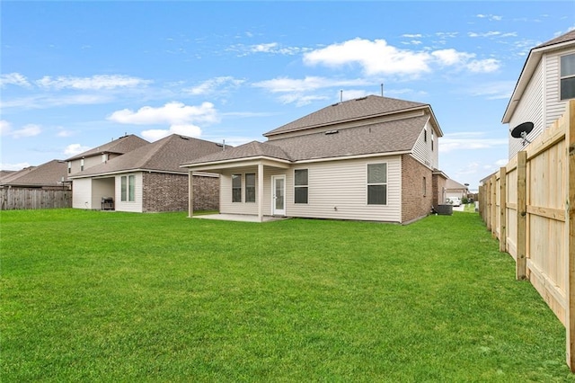 rear view of property with a lawn and a patio