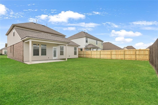 rear view of property featuring a lawn and a patio area