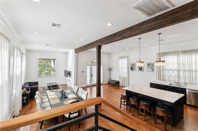 dining area with beamed ceiling and light hardwood / wood-style floors