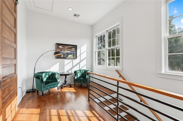 sitting room with plenty of natural light, wood-type flooring, and ornamental molding