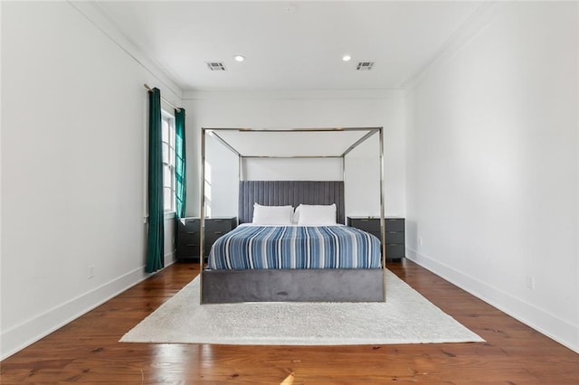 bedroom featuring crown molding and dark wood-type flooring