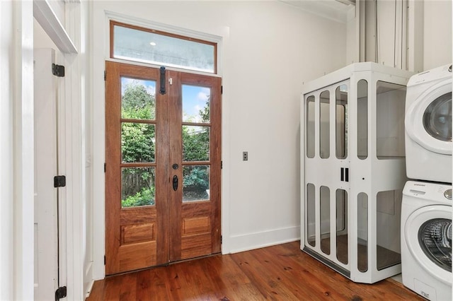 clothes washing area featuring french doors, dark hardwood / wood-style flooring, and stacked washer / drying machine