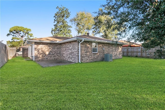 rear view of property featuring a patio area, a yard, and cooling unit