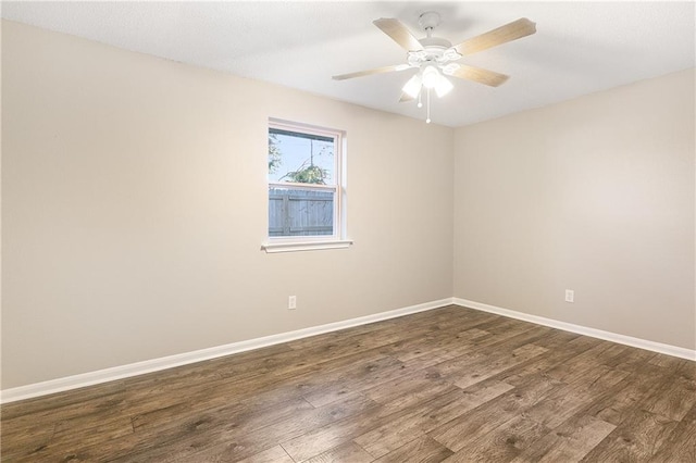 spare room with dark hardwood / wood-style flooring and ceiling fan