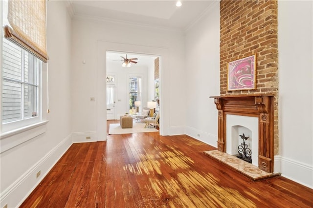 unfurnished living room with hardwood / wood-style floors, ceiling fan, and crown molding