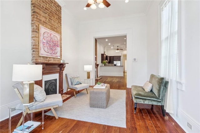 sitting room with a fireplace, hardwood / wood-style floors, and ornamental molding