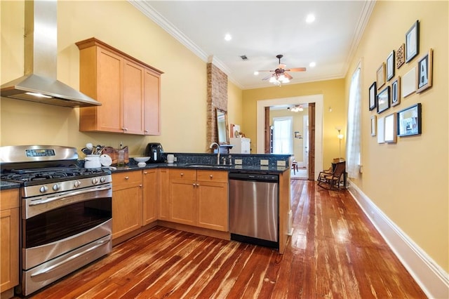 kitchen with kitchen peninsula, wall chimney exhaust hood, stainless steel appliances, dark wood-type flooring, and sink