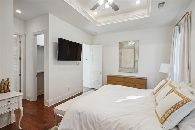 bedroom with ceiling fan, dark hardwood / wood-style floors, and a raised ceiling