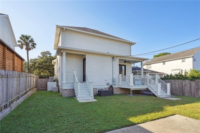 rear view of property with a yard and ceiling fan