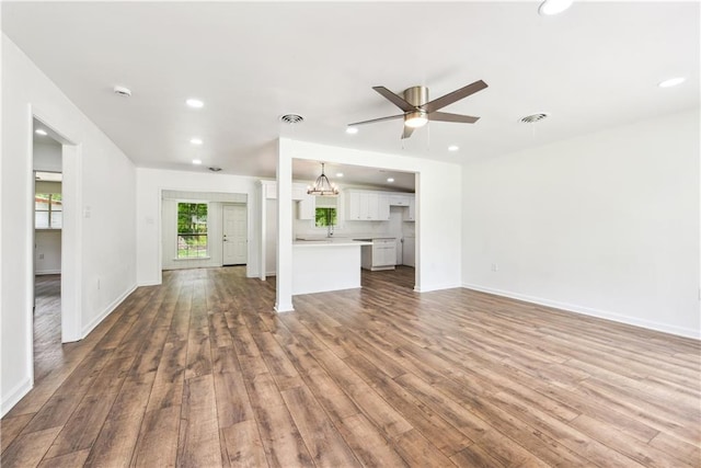 309 W Joan St, Gonzales, LA 70737 - unfurnished living room with ceiling fan with notable chandelier and hardwood / wood-style flooring