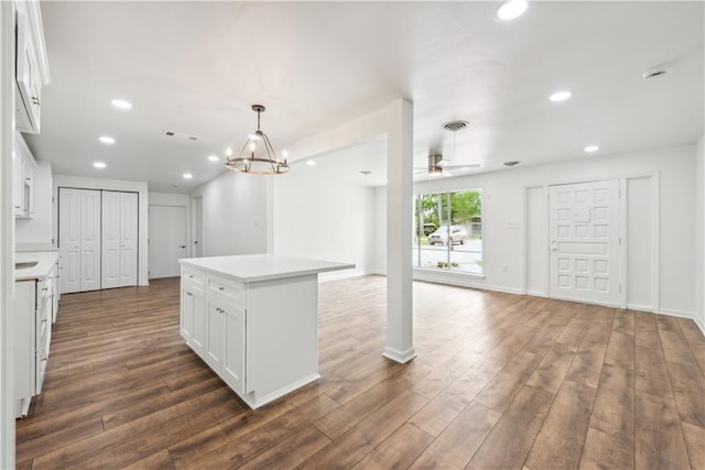309 W Joan St, Gonzales, LA 70737 - kitchen with dark wood-type flooring, a kitchen island, decorative light fixtures, white cabinets, and ceiling fan with notable chandelier