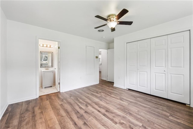 309 W Joan St, Gonzales, LA 70737 - unfurnished bedroom featuring ensuite bathroom, a closet, ceiling fan, and light wood-type flooring