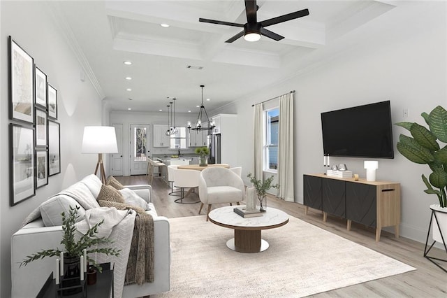 living room with ceiling fan, coffered ceiling, beamed ceiling, light wood-type flooring, and ornamental molding