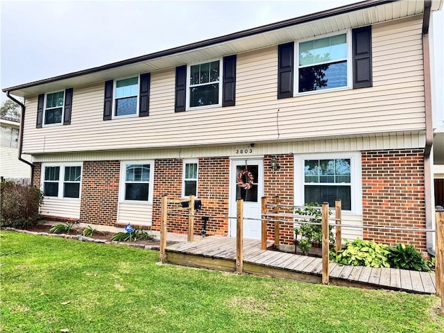 back of house featuring a lawn and a deck