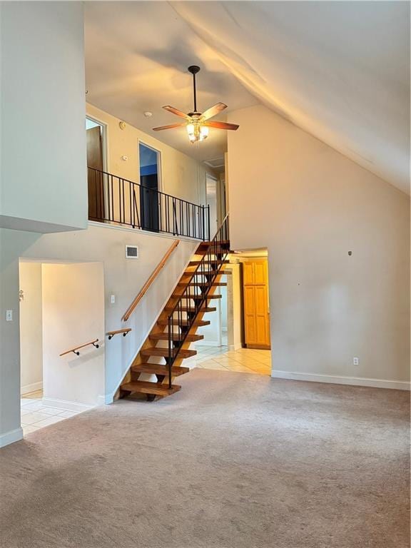 interior space featuring ceiling fan, high vaulted ceiling, and light colored carpet