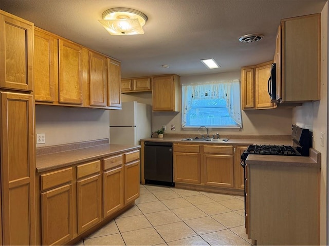 kitchen with light tile patterned flooring, black dishwasher, white fridge, and sink