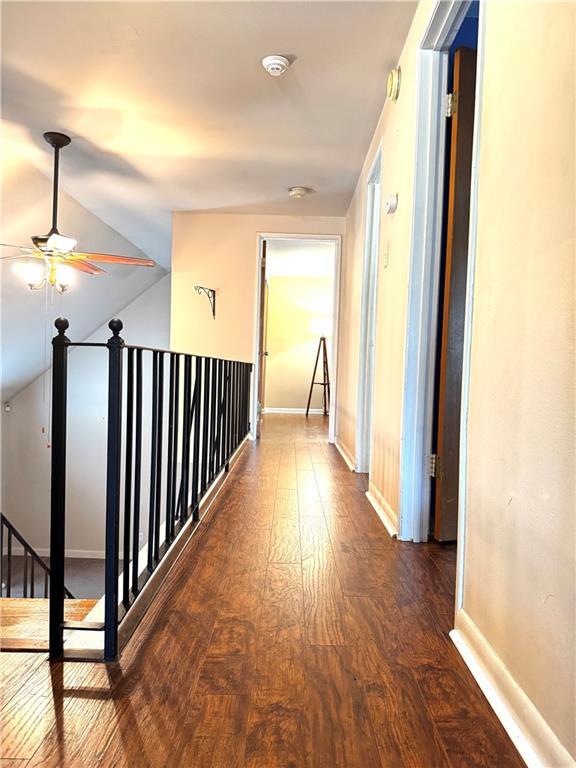 hall with dark hardwood / wood-style floors and vaulted ceiling