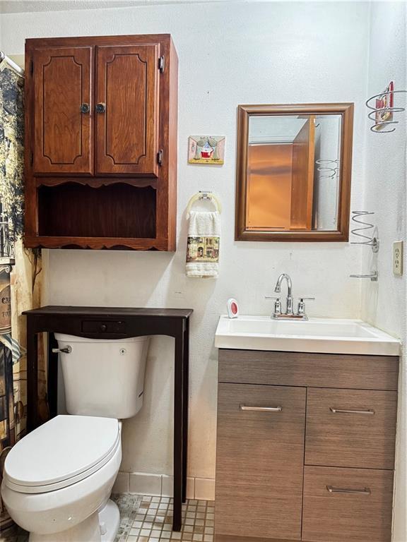 bathroom featuring tile patterned flooring, vanity, and toilet