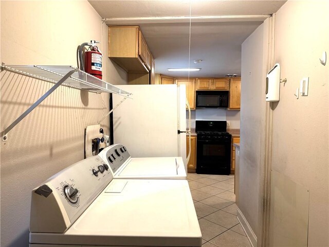 washroom featuring washer and clothes dryer and light tile patterned flooring