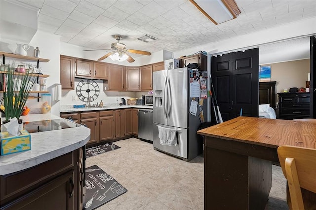 kitchen with wooden counters, appliances with stainless steel finishes, ceiling fan, and sink