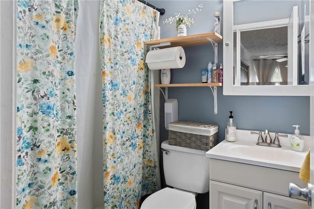 bathroom featuring a shower with shower curtain, vanity, and toilet