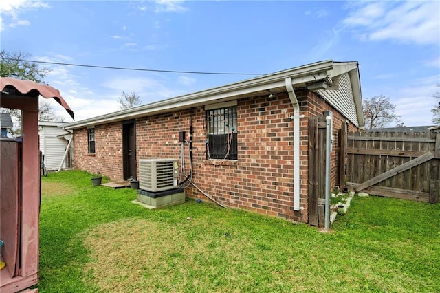 back of house featuring a lawn and central AC