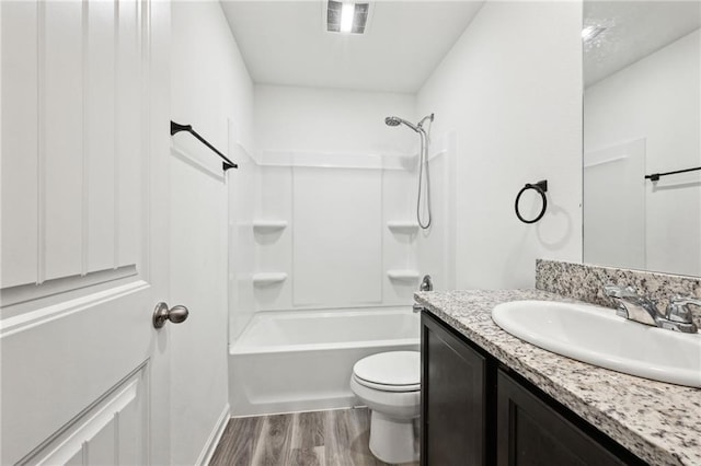 full bathroom with hardwood / wood-style floors, vanity, toilet, and shower / bath combination