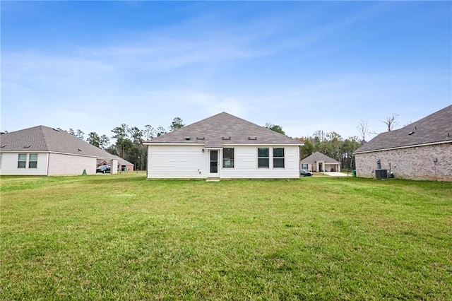 rear view of house with a lawn and central AC