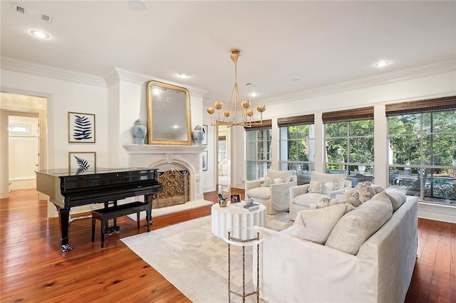 living room with hardwood / wood-style floors, crown molding, and an inviting chandelier