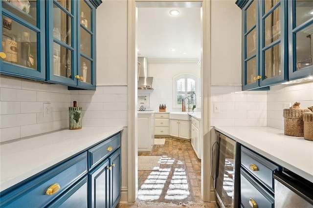 bar with blue cabinets, backsplash, and beverage cooler