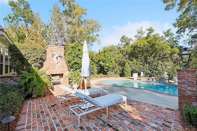 view of swimming pool featuring an outdoor brick fireplace and a patio