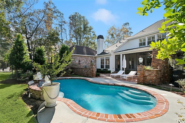 view of pool with a sunroom and a patio